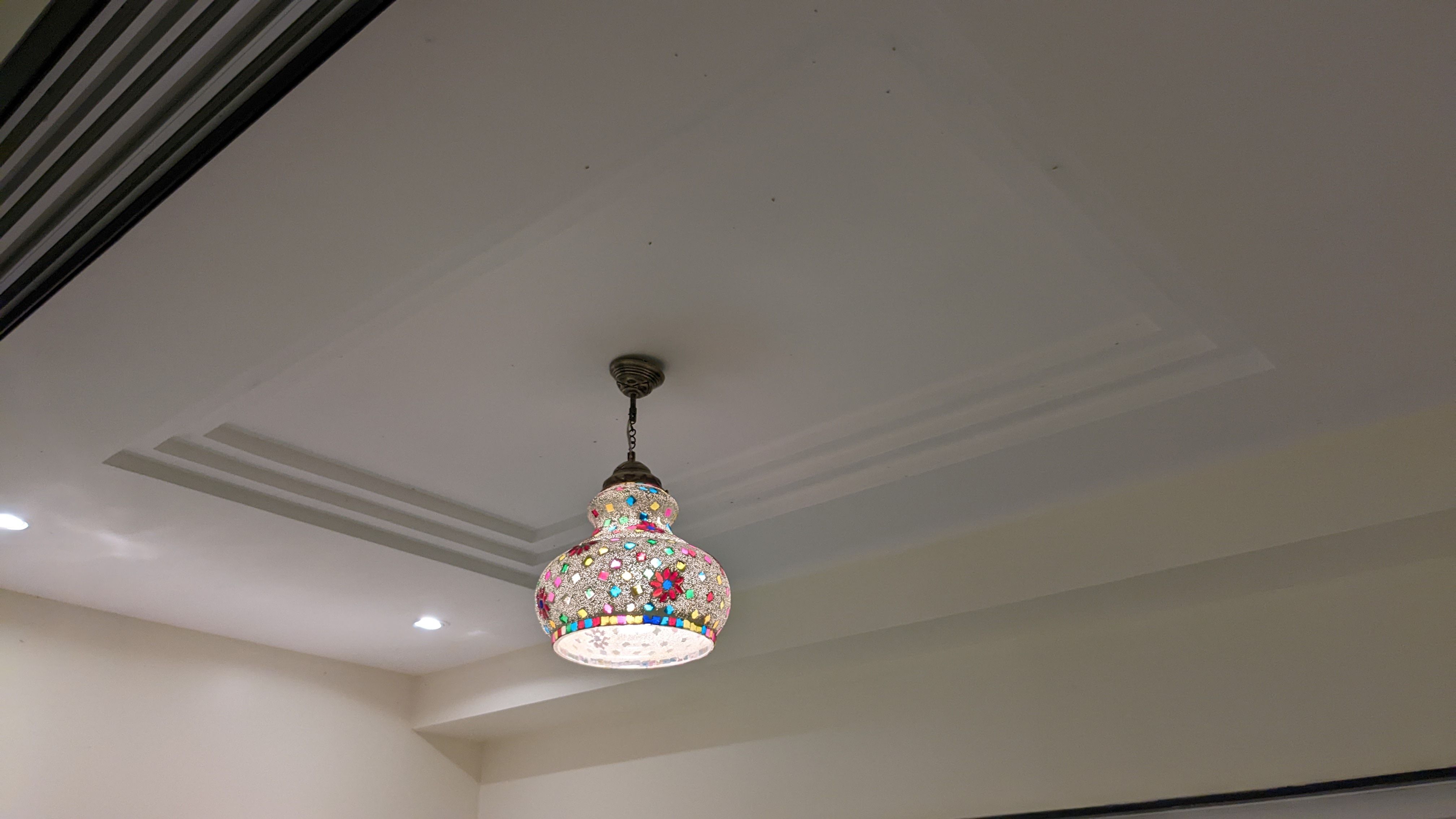 Mosaic glass pendant light set into a tray ceiling