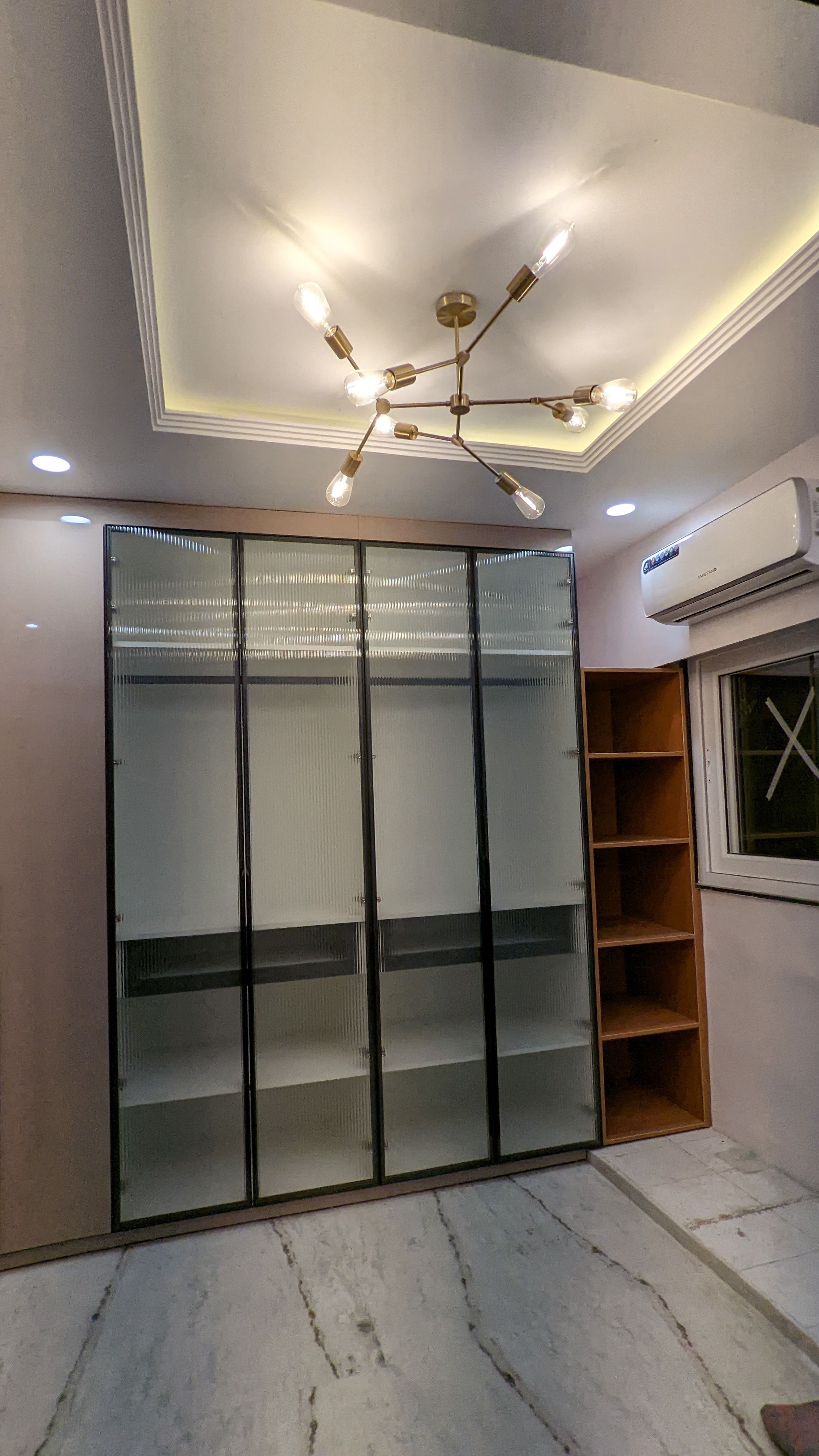 Bedroom wardrobe wall with a sputnik chandelier and frosted-glass shutters