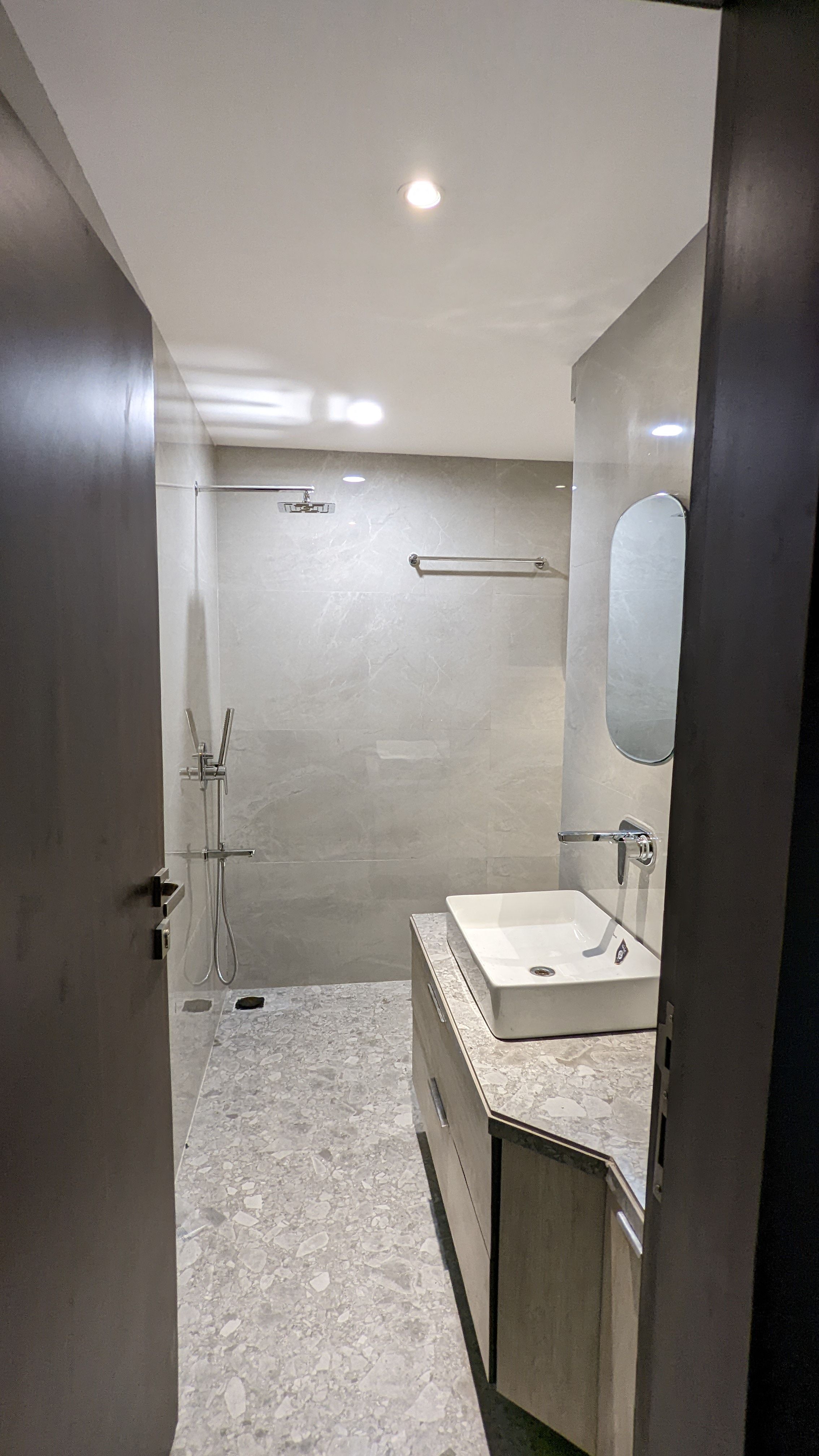 Bathroom with an open rain shower, marble tiling and a floating vanity