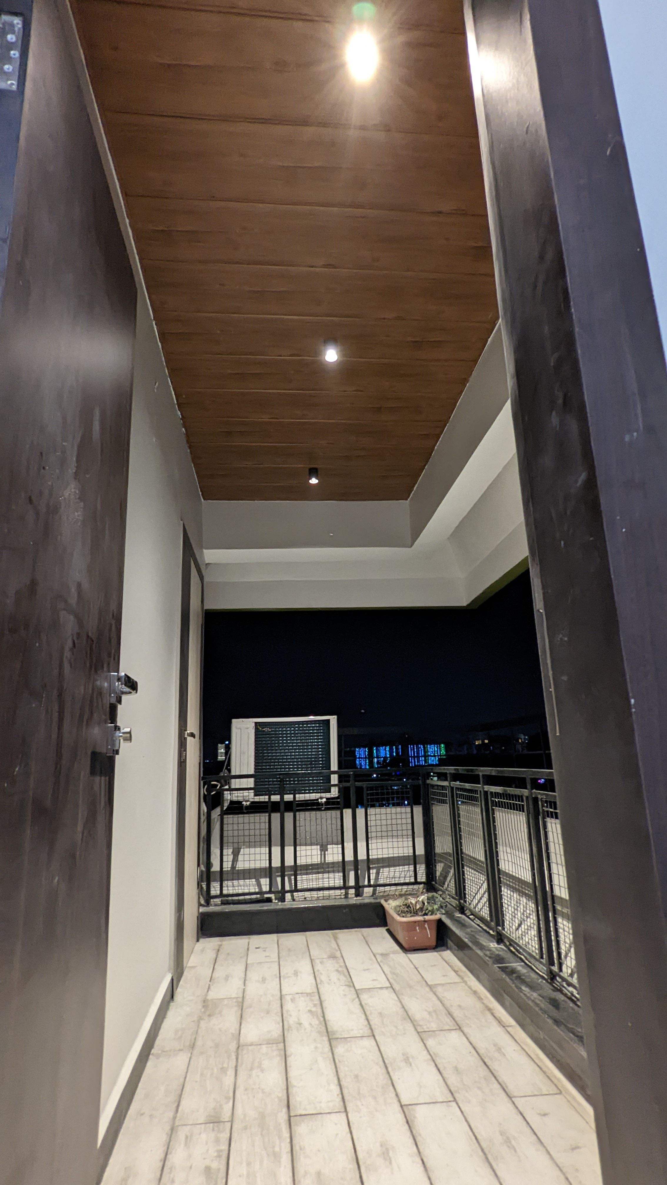 Covered terrace walkway with a wood-clad ceiling, night view